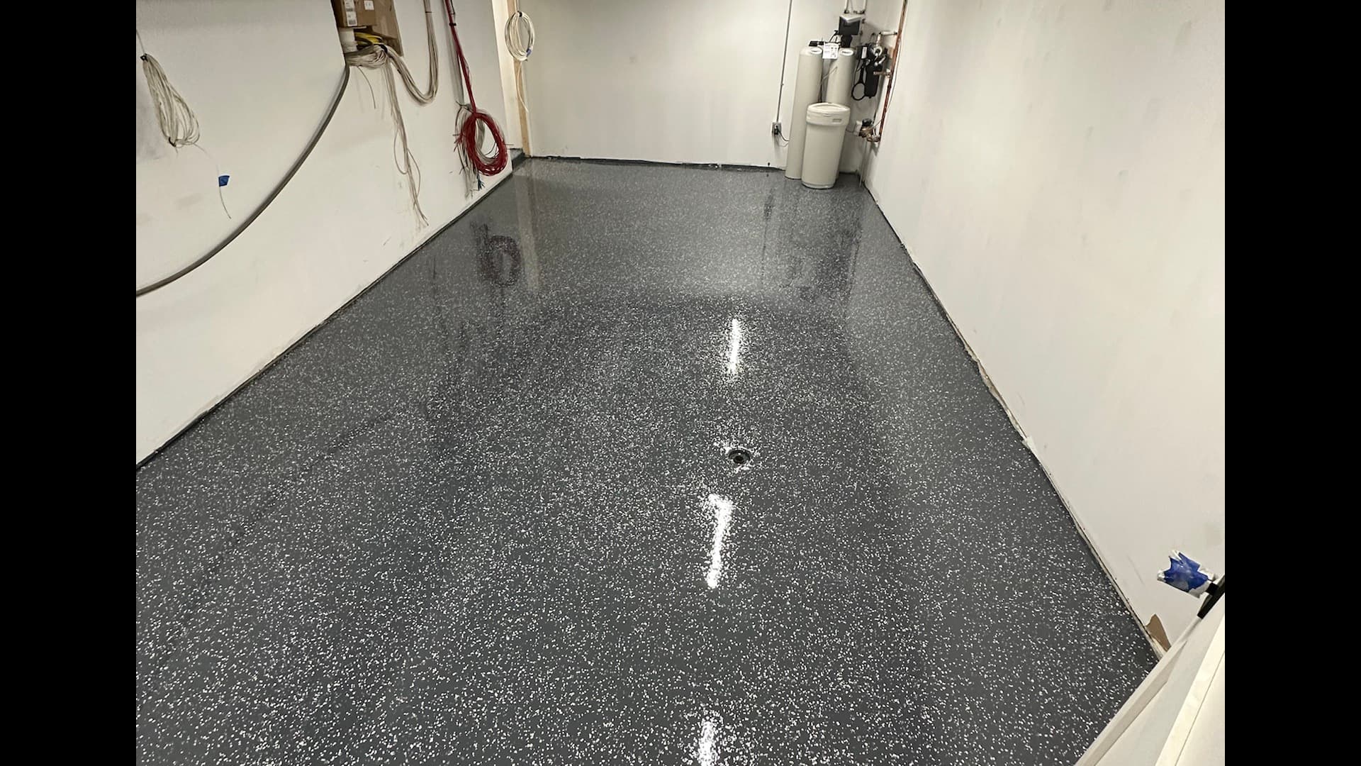 Finished basement with warm lighting and coated floor